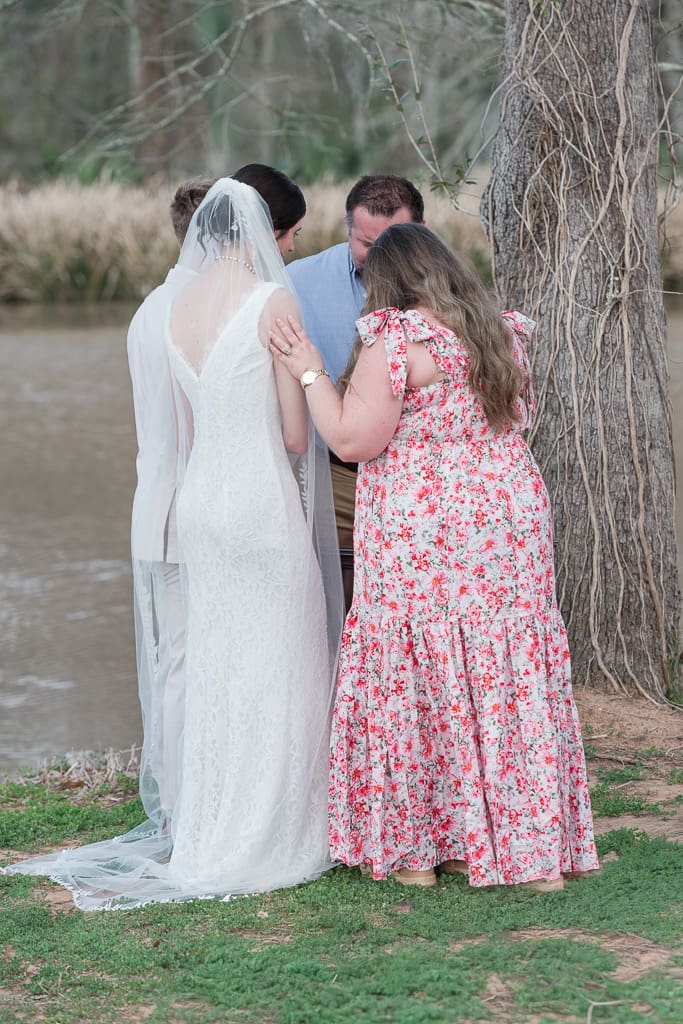 Bride and Groom receiving communion and prayer by Acadiana Wedding Photographer