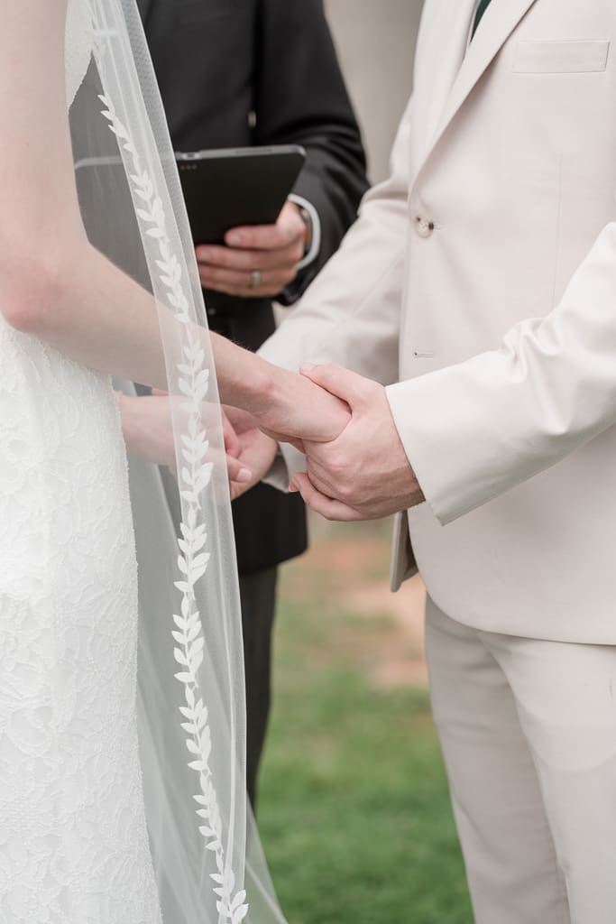 Bride and Groom holding hands at altar by South Louisiana Wedding Photographer