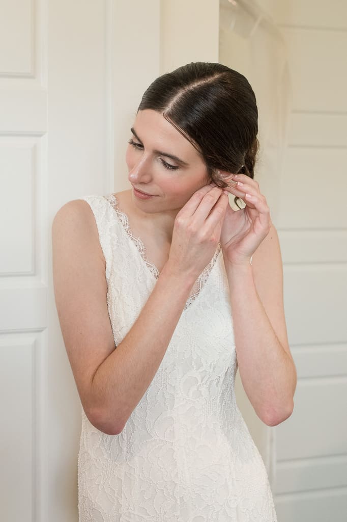 Bride putting on earrings with South Louisiana Wedding Photographer