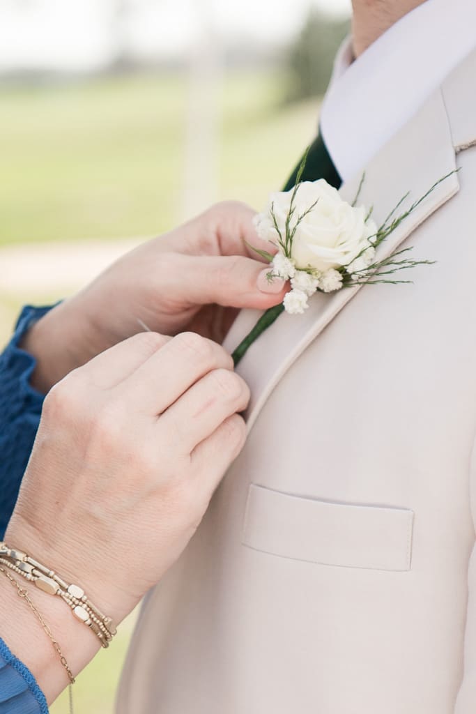 Mother of Groom pinning flower on groom; by South Louisiana Photographer