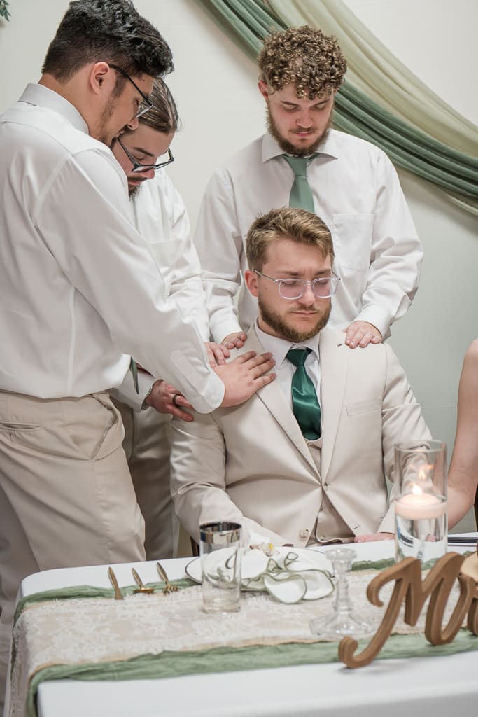 Groomsmen praying over newlyweds at reception, Acadiana Wedding Photographer