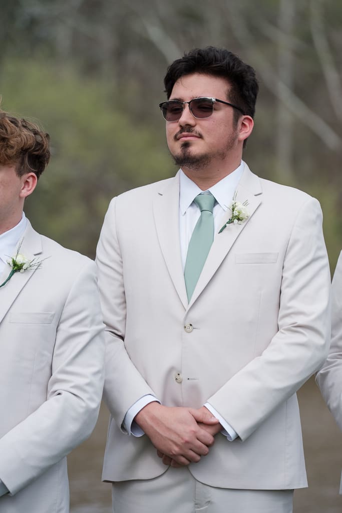 Groomsman watching wedding ceremony by South Louisiana Wedding Photographer