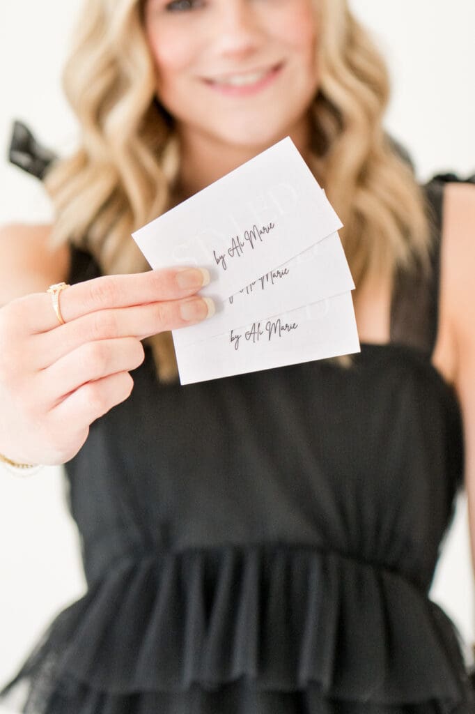 Hairstylist holding business cards for Styled by Ali Marie during branding photoshoot