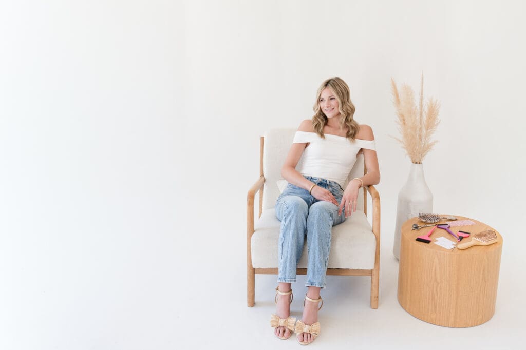 Branding photoshoot client sitting in white chair in studio session