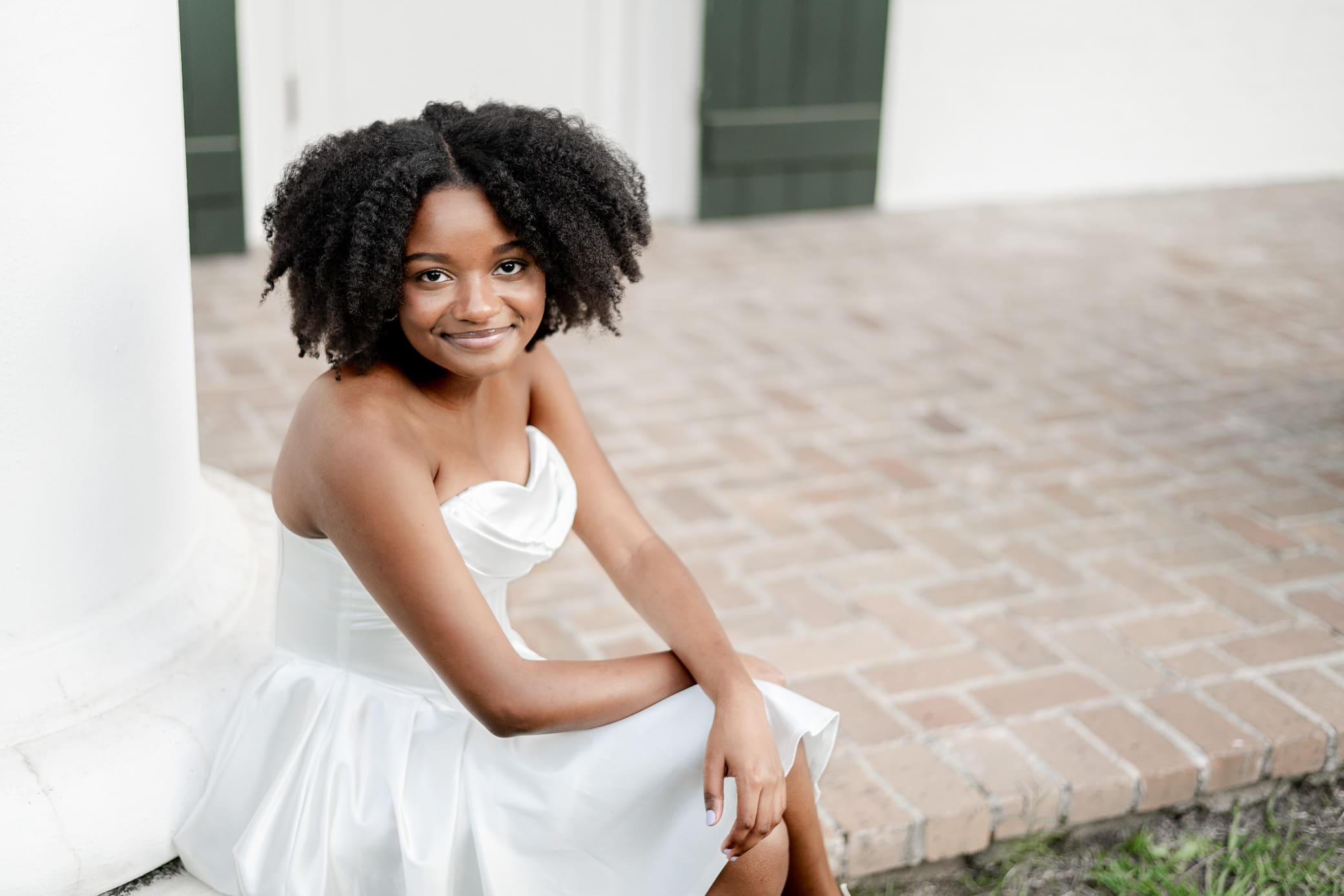 High School Senior in white dress posing during Senior photoshoot